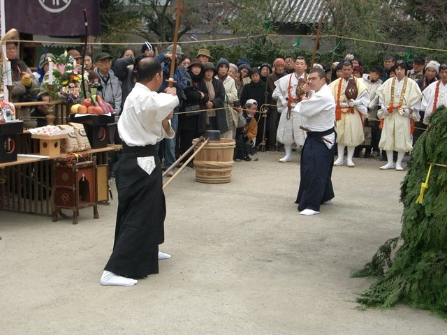 Practitioners demonstrating classical Japanese martial arts before an audience at an outdoor ceremony